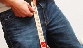 A man measures his penis with a ruler