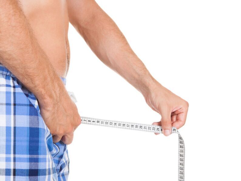 a man measuring his penis with a centimeter